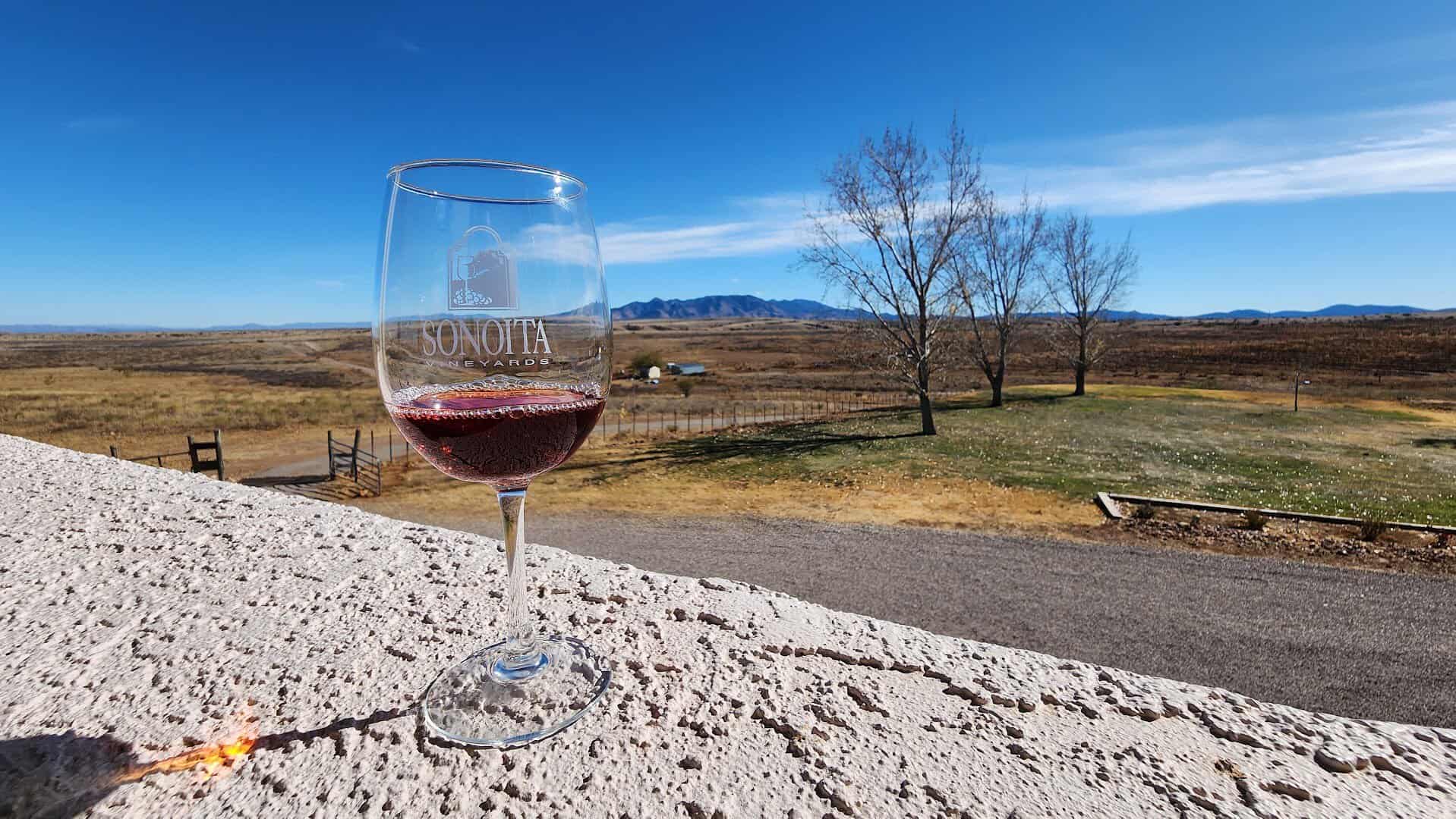 A glass of Sonoita Vineyards wine overlooking the grasslands and mountains near Sonoita, Arizona