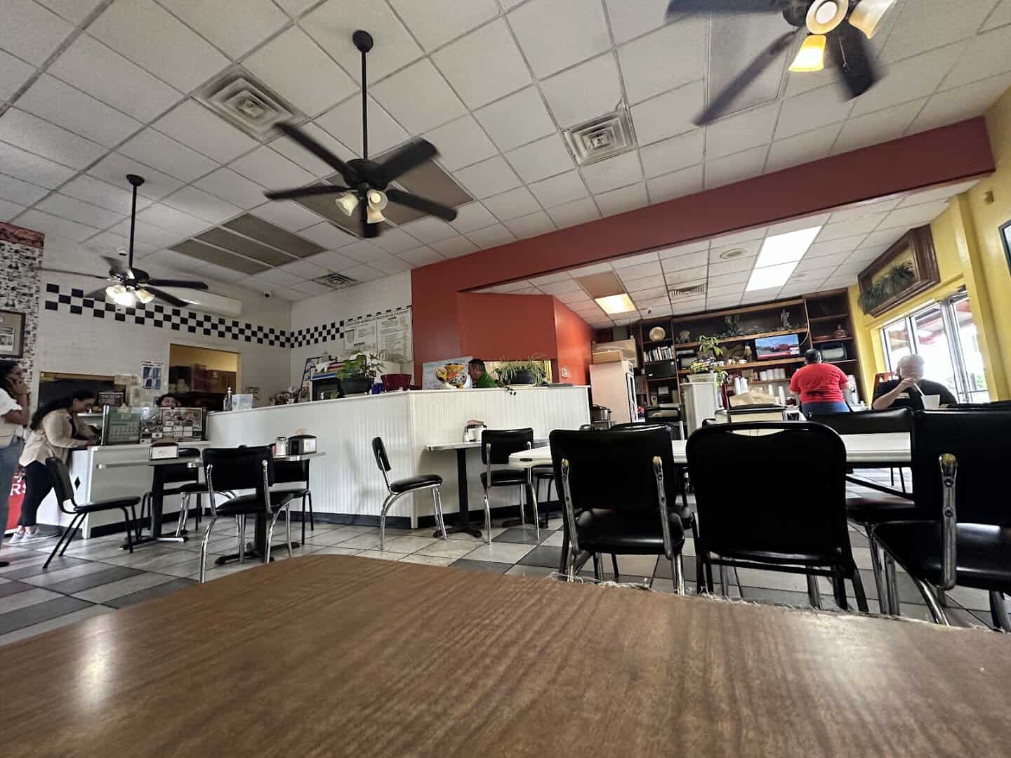 Dining room with checkered floor and ceiling fans at Southside Barbacoa in Corpus Christi