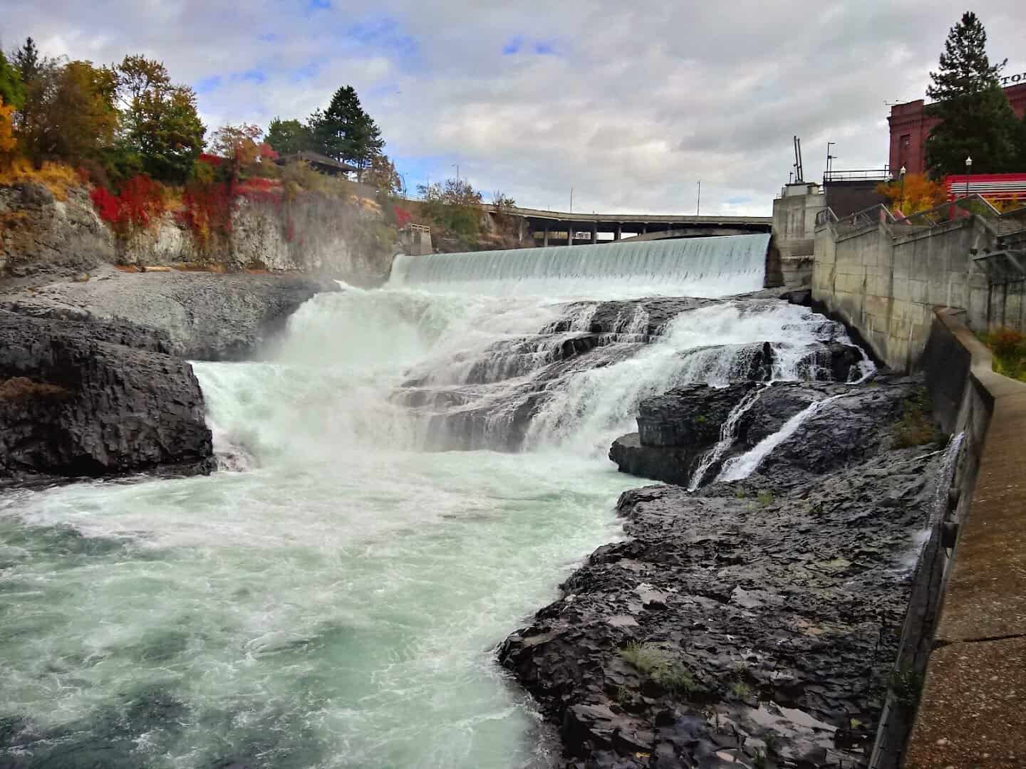 The Spokane Falls churning white past autumn foliage in downtown Riverfront Park, Spokane, Washington