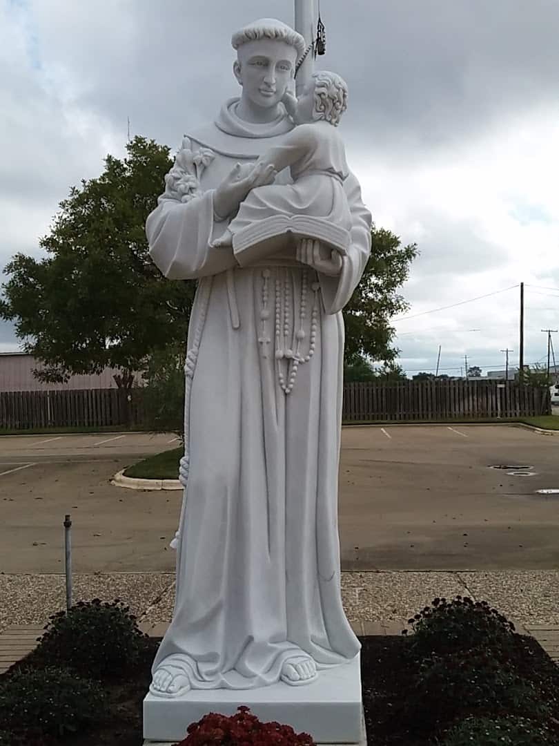 White statue of St. Anthony of Padua on the grounds of St. Anthony Catholic Church in Bryan
