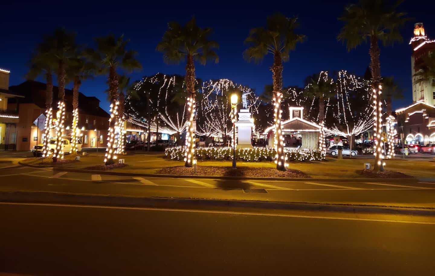 Palms and oaks wrapped in white lights at night around the Plaza de la Constitucion, St. Augustine, Florida