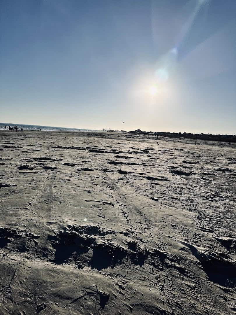Wide groomed sand and surf under the sun at Stewart Beach in Galveston, Texas