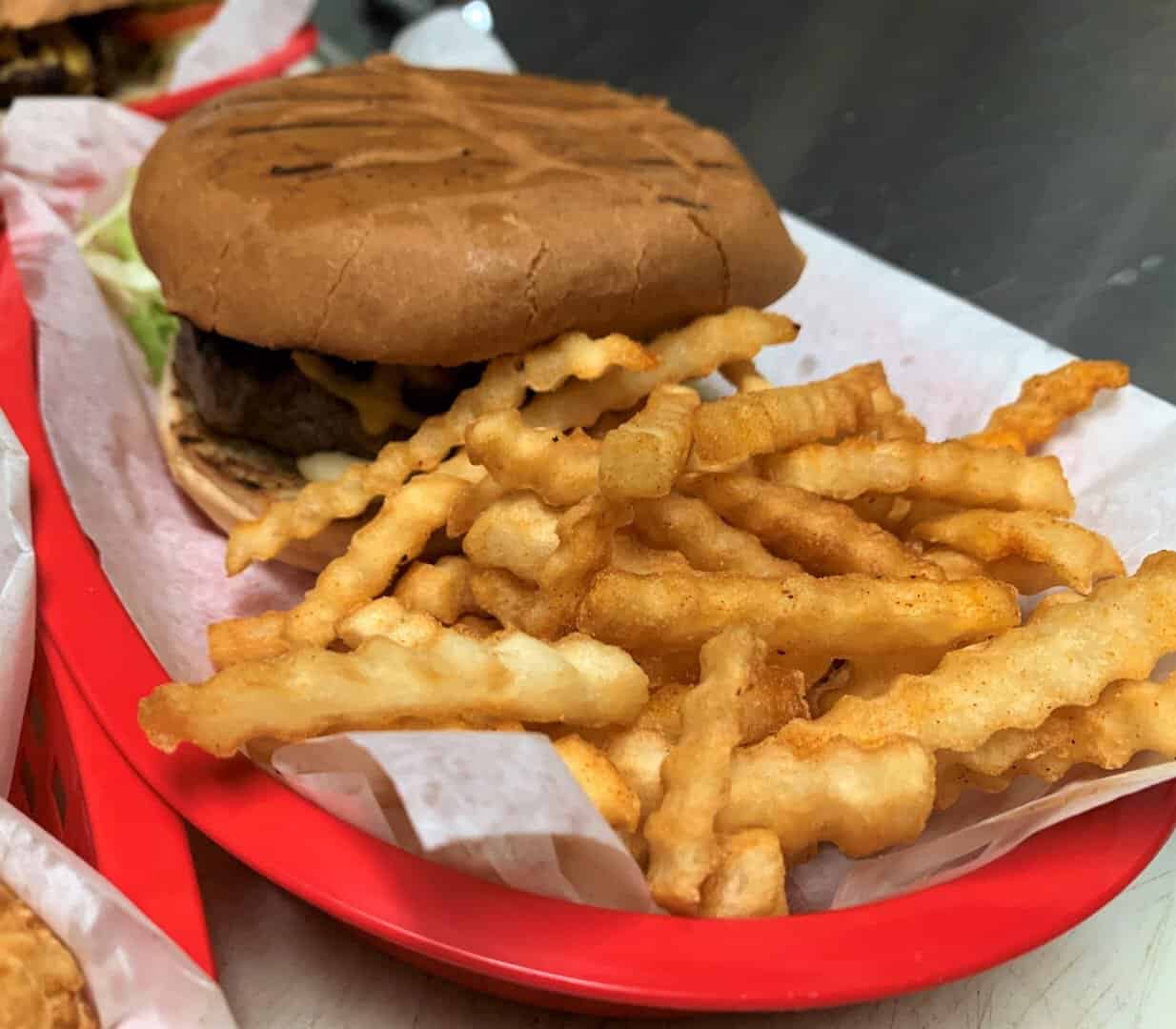Burger basket with crinkle-cut fries at Strokers Ice House in Dallas