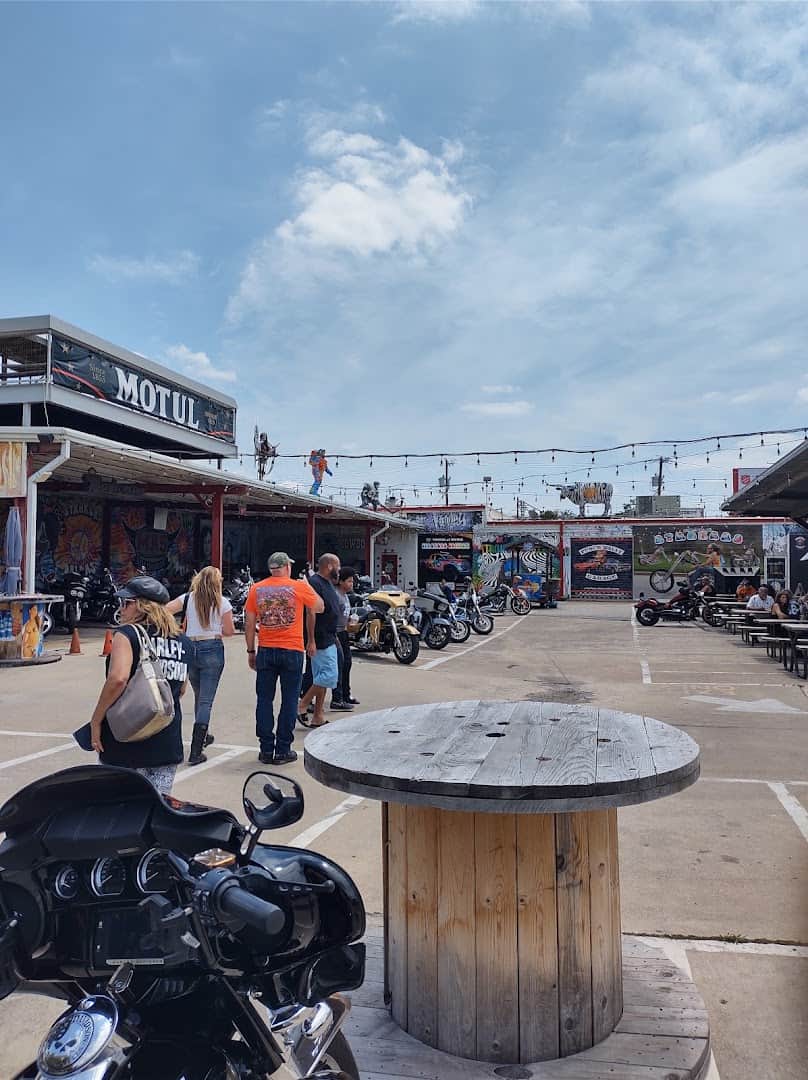Motorcycles and a crowd in the lot at Strokers Ice House in Dallas