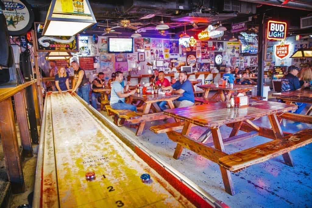 Colorful painted picnic tables inside Strokers Ice House in Dallas