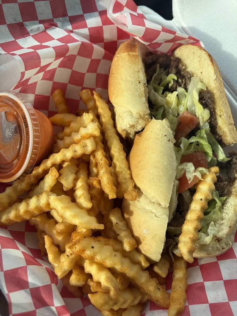 Steak sandwich and fries in a basket at Strokers Ice House in Dallas
