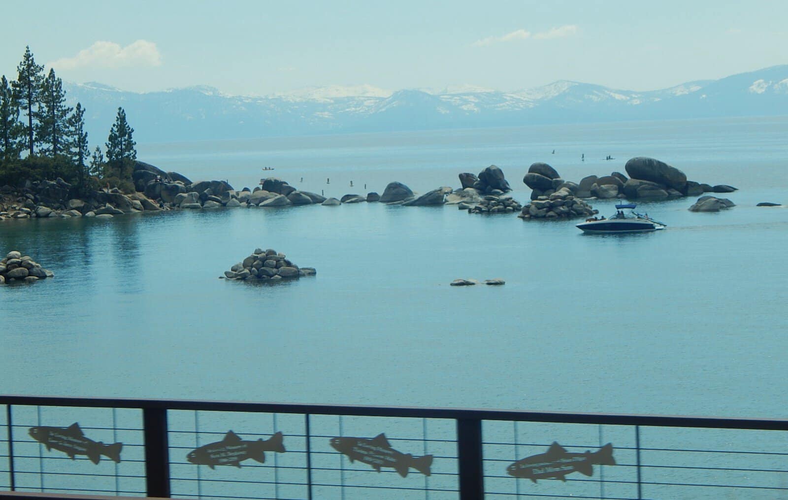 The fish-silhouette railing on the Tahoe East Shore Trail overlooking a turquoise cove, Nevada