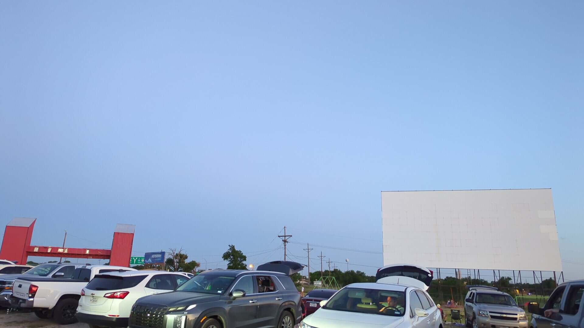 The big screen and a lot full of cars at dusk at Tascosa Drive-In in Amarillo, Texas
