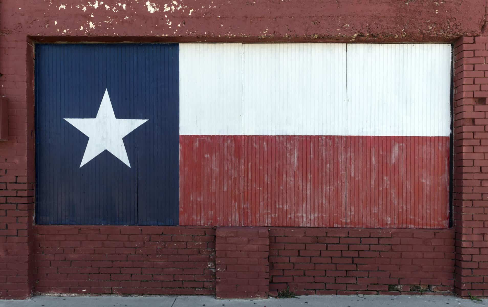 A faded Texas flag painted on an old window in downtown Brownwood, Texas