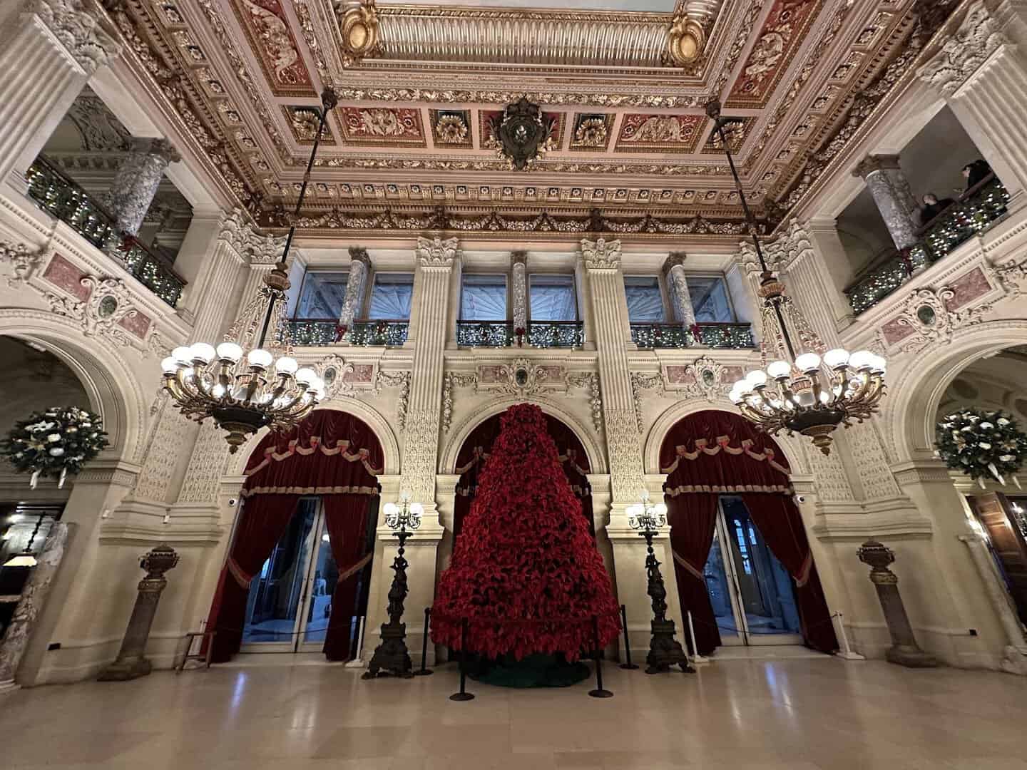 A towering red poinsettia Christmas tree in the Great Hall of The Breakers mansion, Newport, Rhode Island