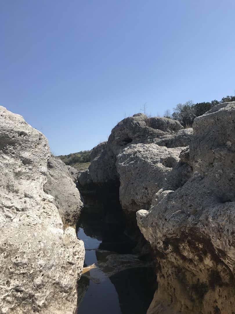 Water-carved limestone potholes and clear pools at The Narrows on the Blanco River, Texas