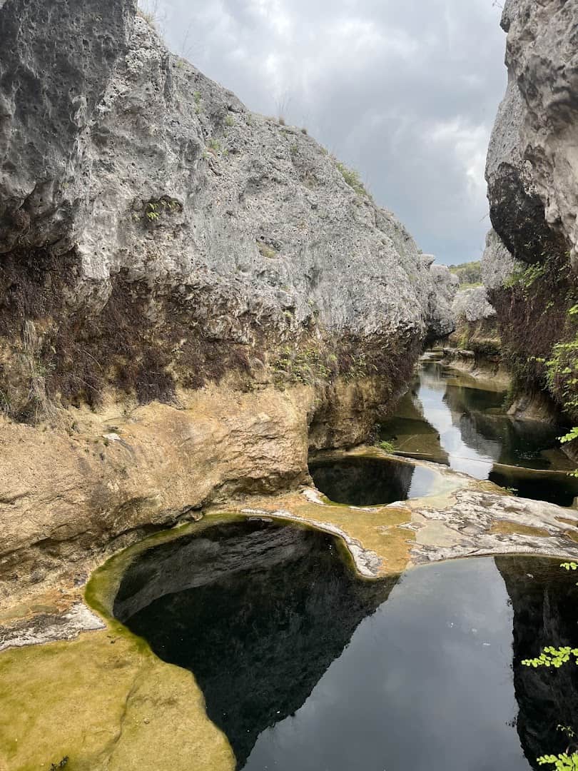 Clear layered pools reflecting the canyon walls at The Narrows on the Blanco River, Texas