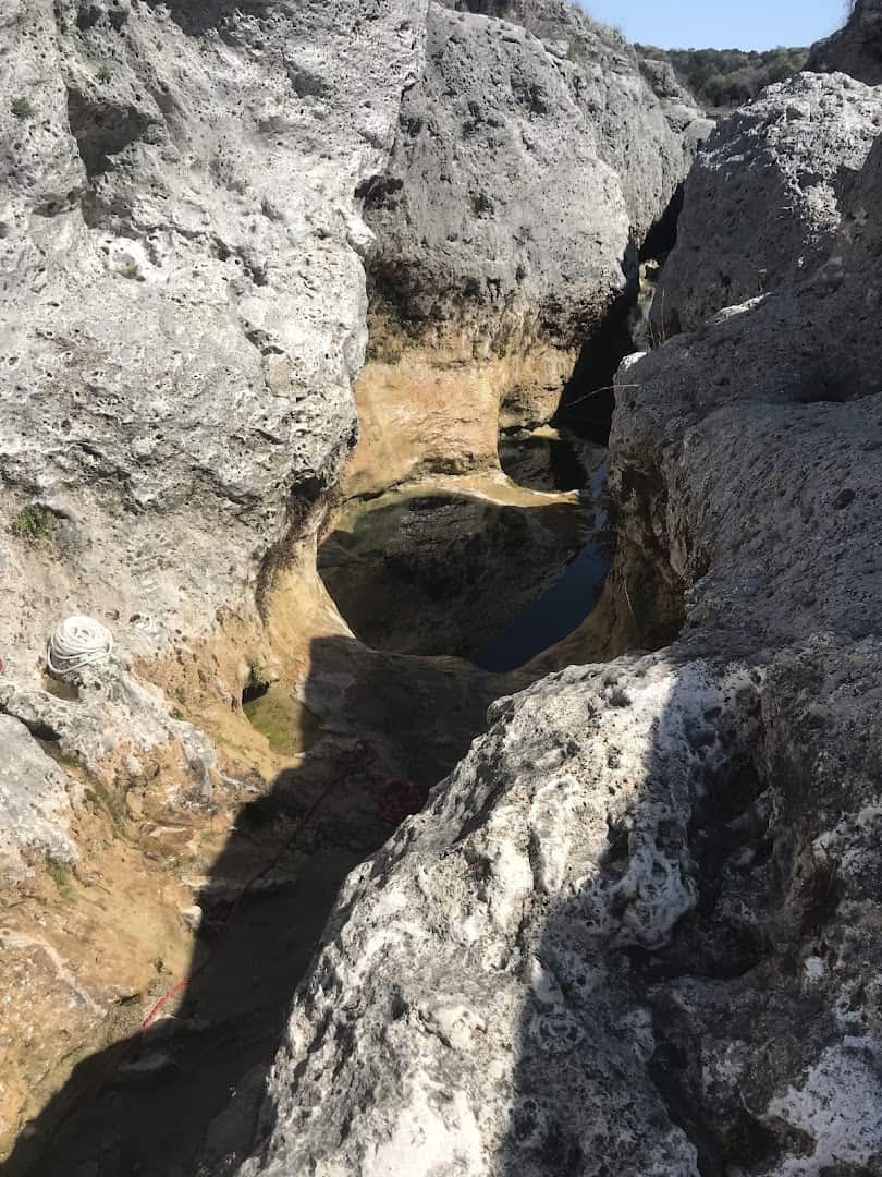 Smooth honeycombed white limestone shelves carved by water at The Narrows on the Blanco River, Texas