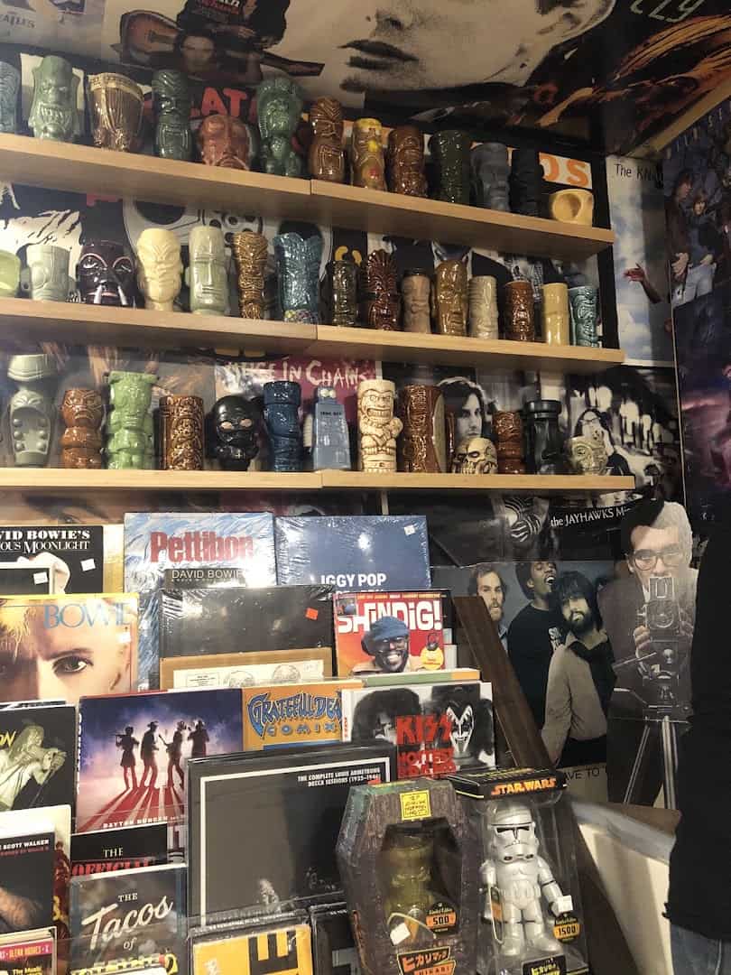 Shelves of tiki mugs above records and collectibles at Sigs Lagoon in Houston