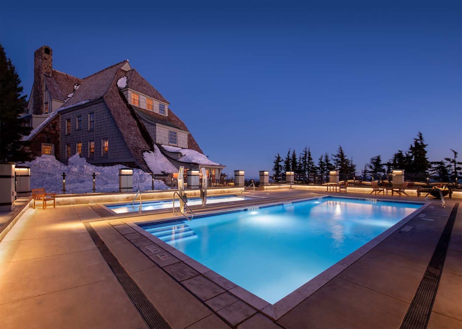 Timberline Lodge glowing at dusk surrounded by deep snow on Mount Hood, Government Camp, Oregon