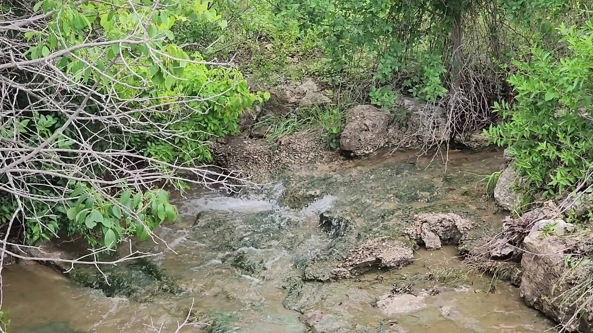 Tonk Creek at low water with exposed rock bed at Tonkawa Falls City Park in Crawford, Texas