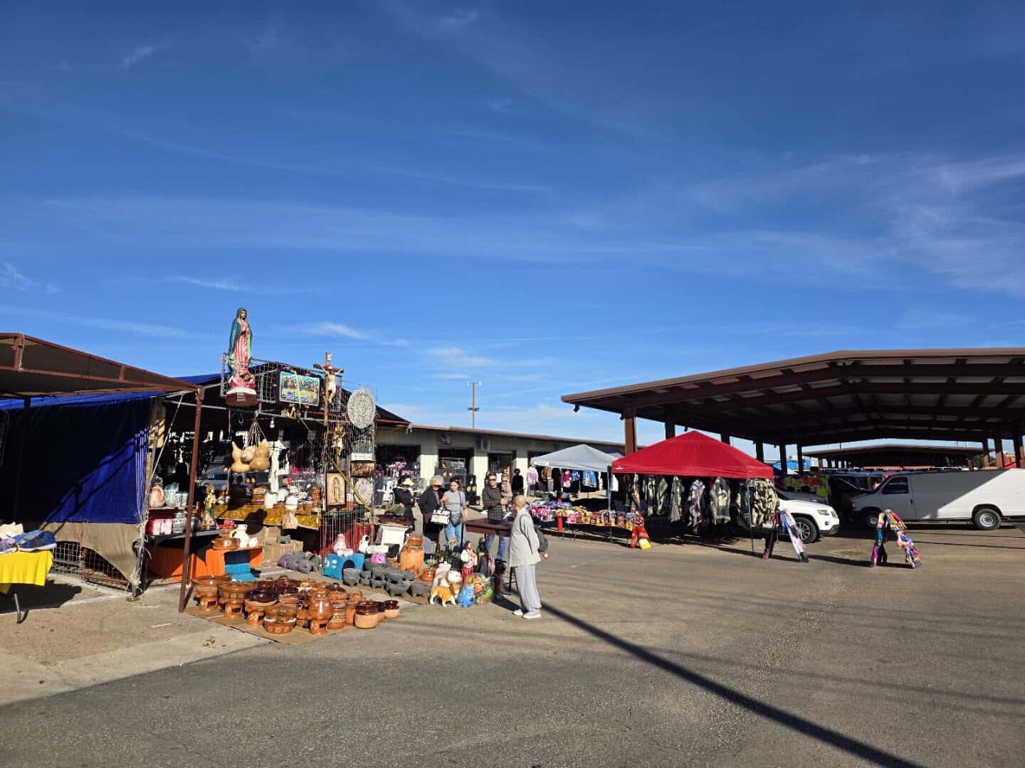 Outdoor stalls of pottery and blankets at Traders Village flea market in Grand Prairie, Texas