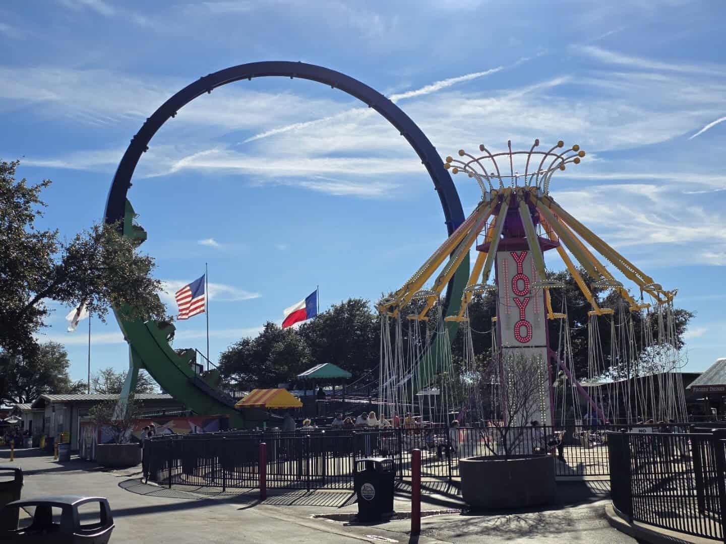 Roller coaster loop and swing tower ride at Traders Village in Grand Prairie, Texas
