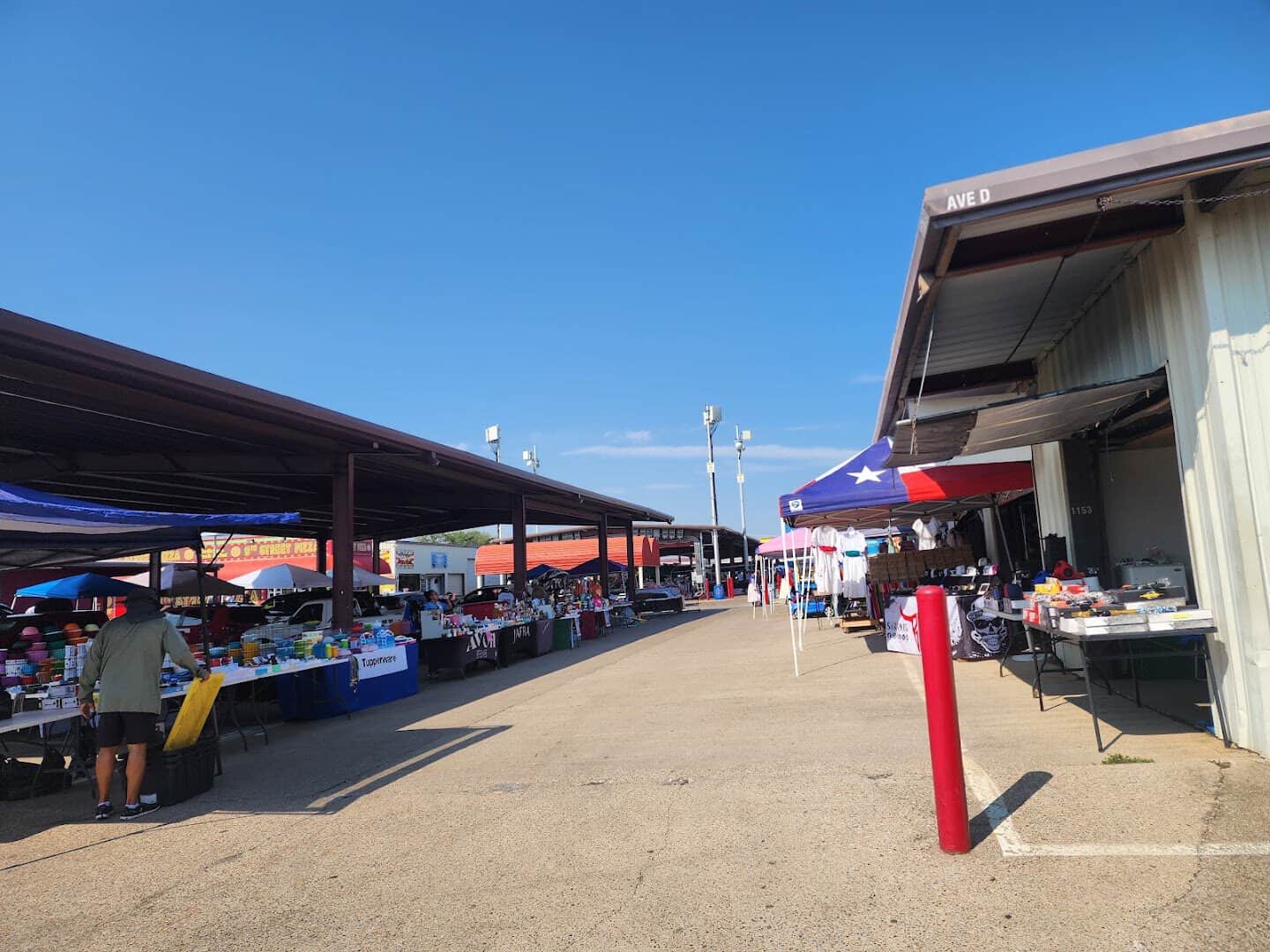 Outdoor vendor lanes with tables of goods at Traders Village in Grand Prairie, Texas