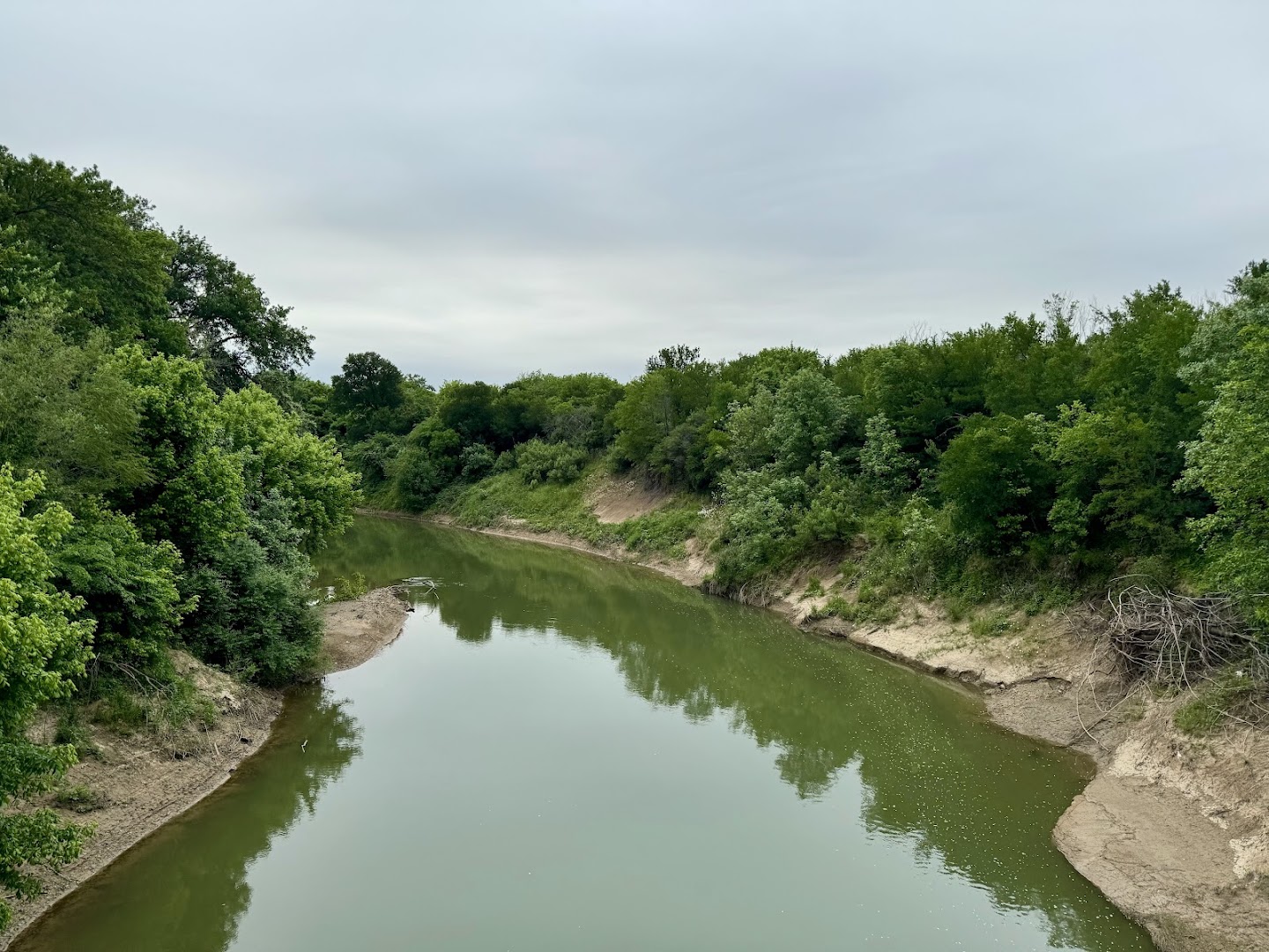 The Trinity River winding between wooded banks at River Legacy Park in Arlington