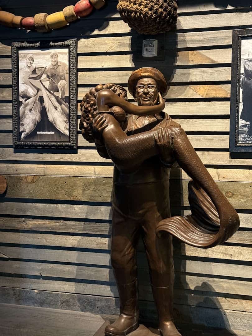 Bronze statue of Uncle Buck holding a mermaid at Uncle Buck's Fishbowl and Grill in Round Rock