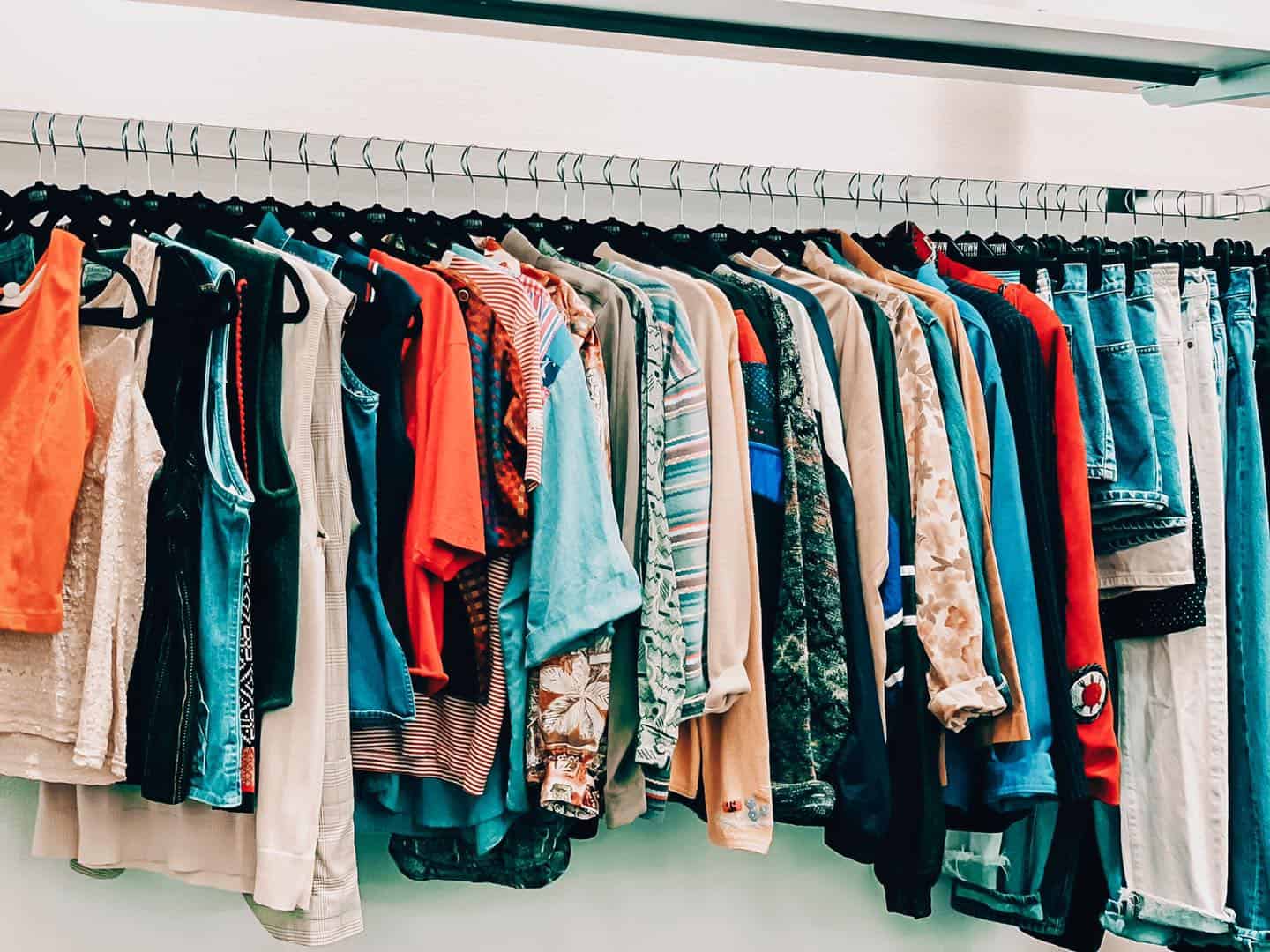 A rack of colorful clothing at Uptown Cheapskate Tyler