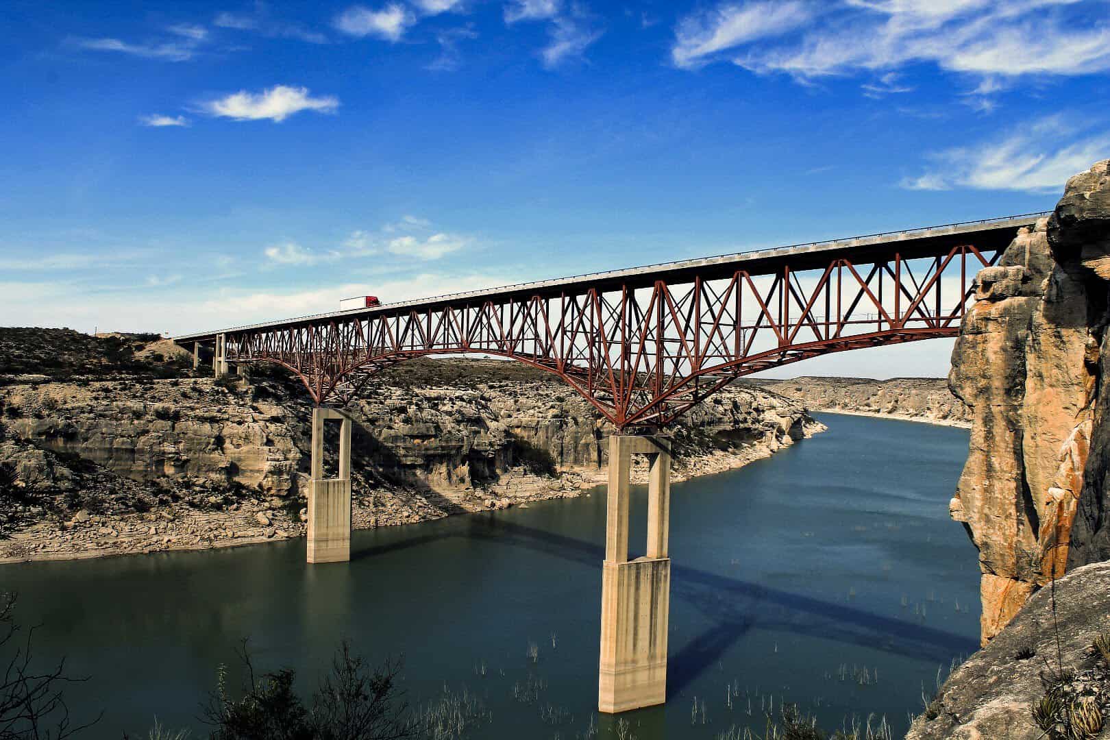 The US 90 Pecos River High Bridge on its two tall piers above the green Pecos River canyon in Texas