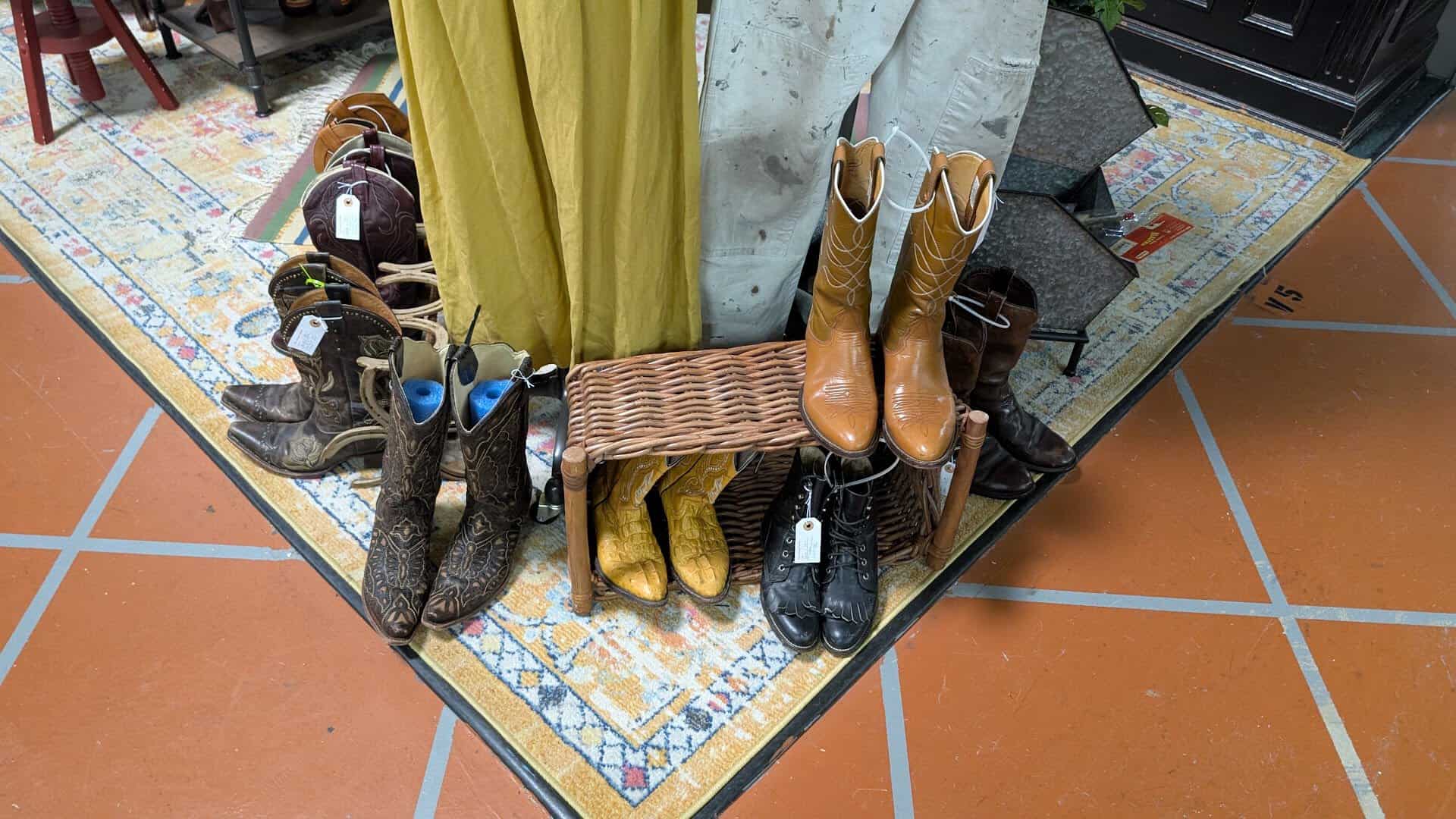 Vintage cowboy boots displayed on a rug at The Antique Gallery of Houston in Spring Texas