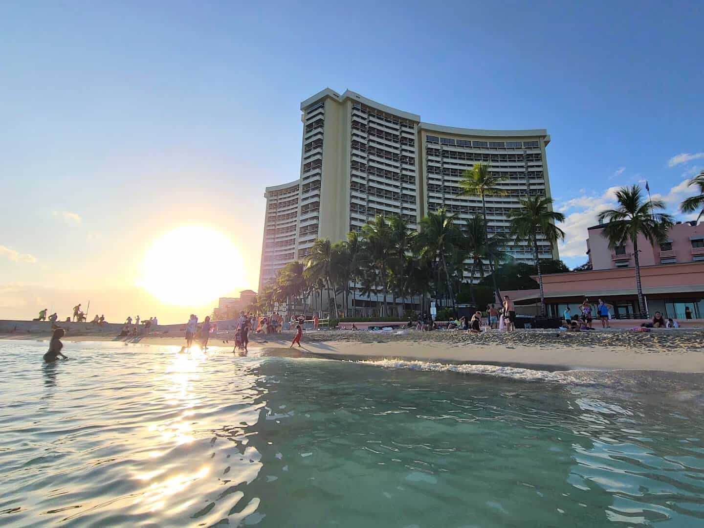Waikiki Beach at sunset with palms and beachfront hotel in Honolulu, Hawaii