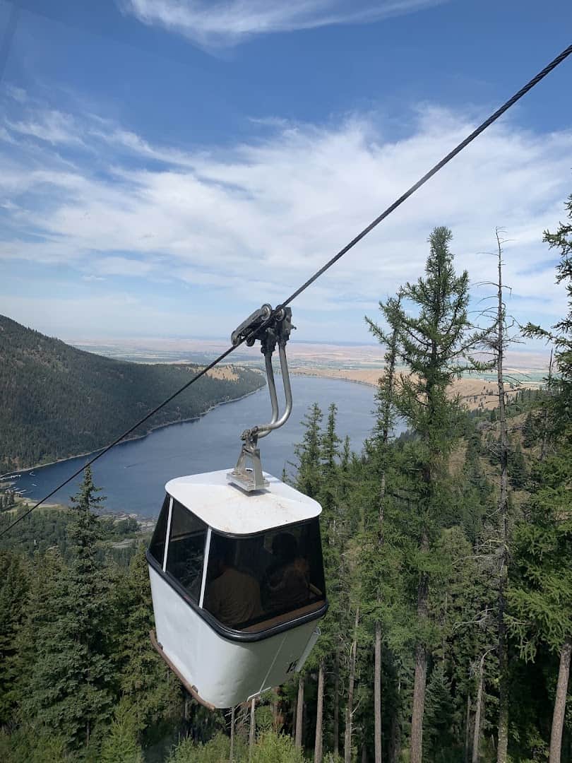 A Wallowa Lake Tramway gondola car climbing above forest and lake near Joseph, Oregon