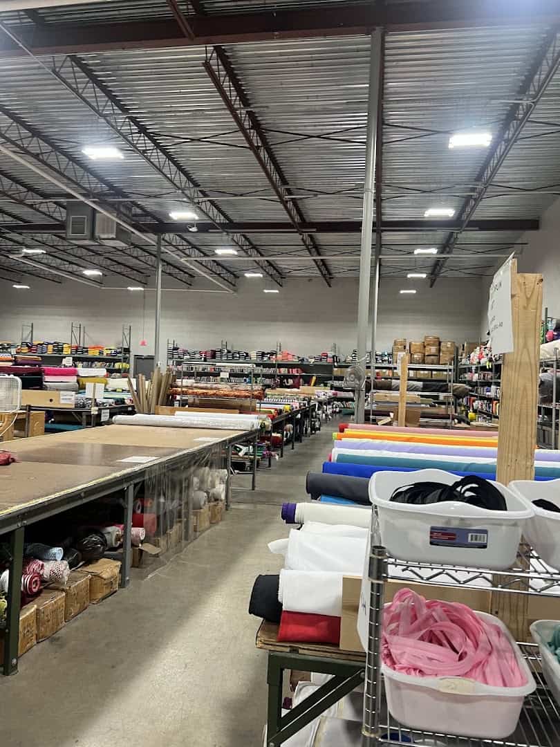 Wide interior of the Wherehouse Fabrics warehouse with tables and bolts of fabric in Dallas