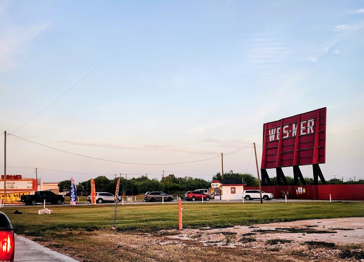Wes-Mer Drive-In sign and cars at dusk in Mercedes, Texas