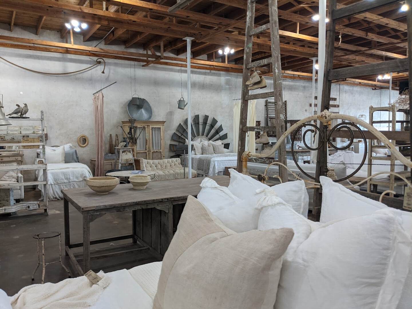 White linen sofas and pillows in the open warehouse at Carol Hicks Bolton Antiques in Fredericksburg