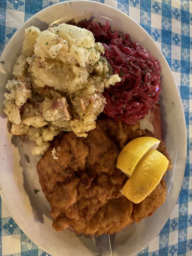 Golden fried wienerschnitzel with lemon, red cabbage and German potato salad at Walburg German Restaurant