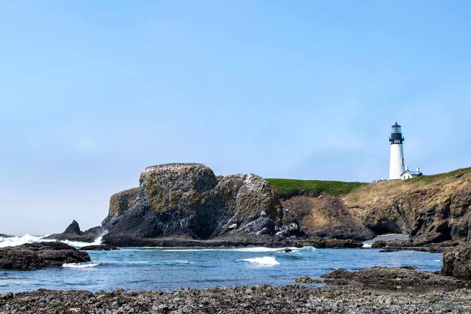 Yaquina Head Lighthouse on the green headland above the surf near Newport, Oregon