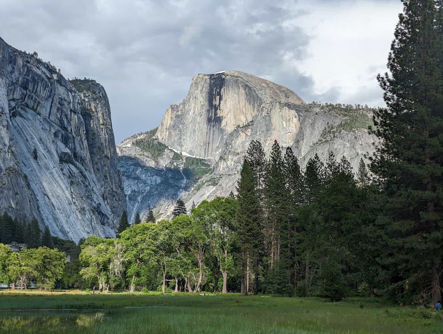 Wide view of Yosemite Valley with granite cliffs and Half Dome in Yosemite National Park, California
